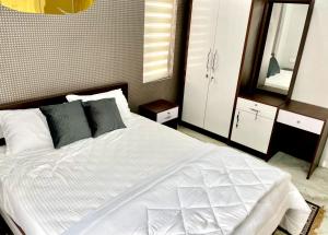 a bedroom with a large white bed and a mirror at Appartment in Ernakulam