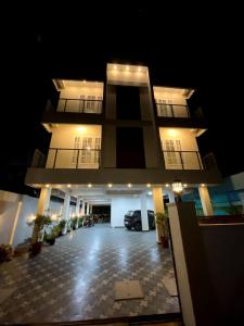 a large building with a parking lot at night at Appartment in Ernakulam