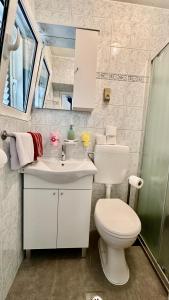 La salle de bains est pourvue de toilettes blanches et d'un lavabo. dans l'établissement Arbium Classic, à Rab