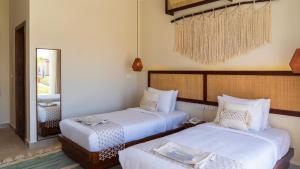 a bedroom with two beds and a mirror at Kynd 01 - Ras El Hikma, GAIA Compound in Marsa Matruh +22 photos