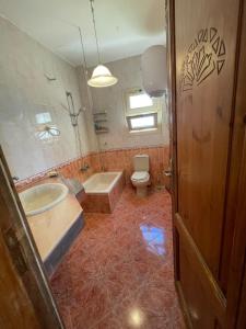 a bathroom with a tub and a toilet and a sink at فيلا للرفاهية Blu Lagon in Ras Sedr