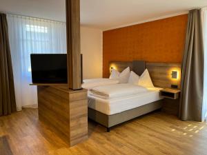 um quarto com uma cama e uma televisão de ecrã plano em WESTSIDE Hotel em Munique