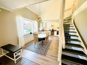 a kitchen and dining room with a staircase and a table at Nyrenoverat 2-våningshus in Norrköping
