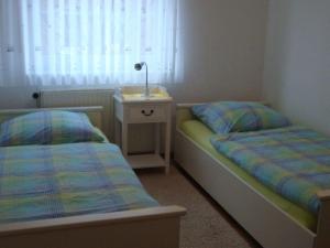 a bedroom with two beds and a night stand with a lamp at Nice holiday home near town centre in Juist