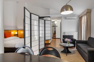 uma sala de estar com uma cama, um sofá e uma mesa em Hotel Ancora em Verbania