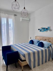 a bedroom with a bed and a blue chair at Maris Apartment by Tenuta Pinto in Mola di Bari