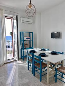 a white and blue dining room with a table and chairs at Maris Apartment by Tenuta Pinto in Mola di Bari