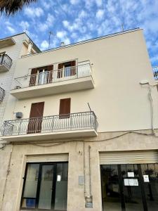 a white building with a balcony on top of it at Maris Apartment by Tenuta Pinto in Mola di Bari +10 photos