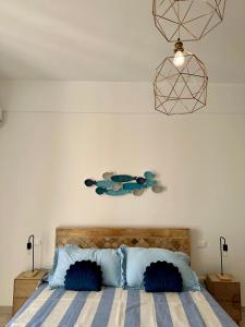 a bedroom with a large bed with blue pillows at Maris Apartment by Tenuta Pinto in Mola di Bari