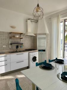 a kitchen with a table with blue chairs in it at Maris Apartment by Tenuta Pinto in Mola di Bari