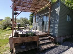 eine Hütte mit einer Terrasse mit einer Pergola in der Unterkunft Tiny house cosy in Anduze