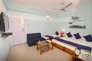 a bedroom with a bed and a chair and a table at Ganpati Hotel in Bhopal