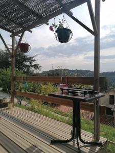 une terrasse couverte avec un banc et deux paniers suspendus dans l'établissement Tiny house cosy, à Anduze