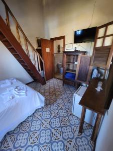 a bedroom with a bed and a staircase and a table at Capricho Asturiano in Santo Antônio do Leite