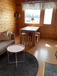 sala de estar con mesa y sofá en Yllästölli 2 D, Äkäslompolo en Kolari