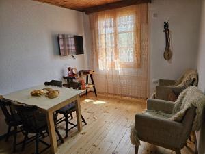 sala de estar con mesa de madera y sillas en Traditional House Srna en Mojkovac