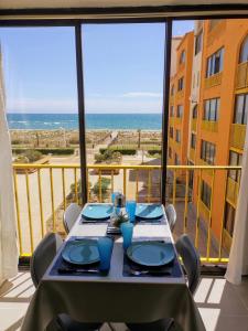 stół na balkonie z widokiem na ocean w obiekcie appartement vue mer pour 4 personnes accès direct plage wifi haut débit gratuit w mieście Le Barcarès