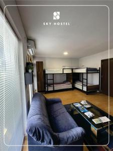 Sky Hostel في بيخا: غرفة معيشة مع أريكة زرقاء وطاولة