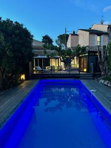een groot blauw zwembad voor een huis bij Au calme, piscine et spa privés in Roquebrune-sur-Argens