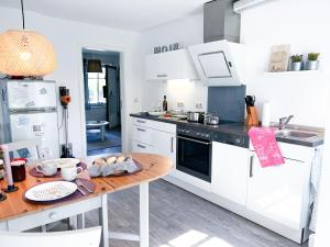 eine Küche mit weißen Geräten und einem Holztisch in der Unterkunft Ferienwohnung Sonnentraum in Bannesdorf