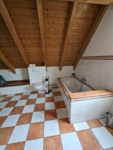 a bathroom with a tub and a tiled floor at Casa De Campo Ladestation E - Auto neu renoviert in Trabelsdorf