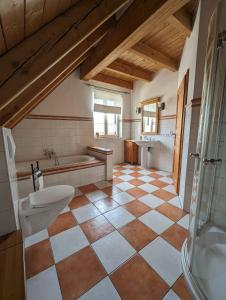 a bathroom with a tub and a toilet and a sink at Casa De Campo Ladestation E - Auto neu renoviert in Trabelsdorf