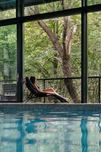 a woman laying in a chair next to a swimming pool at DiliJazz Hotel & Restaurant in Dilijan