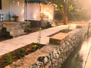 a stone retaining wall next to a river at The chocolate frog in Udaipur