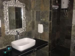 a bathroom with a sink and a mirror on a counter at The chocolate frog in Udaipur