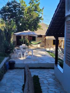 a patio with a table and an umbrella at Brisa da Serra Hotel Pousada Pirenopolis in Pirenópolis