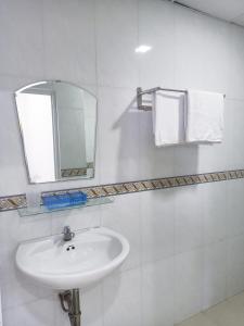 芽莊的住宿－Mangolia Hotel，白色的浴室设有水槽和镜子