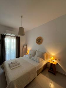 ein Schlafzimmer mit einem weißen Bett mit zwei Handtüchern darauf in der Unterkunft Asteras in Antiparos