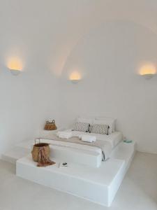 a white room with a bed with two pillows at as holiday caves in Mesaria