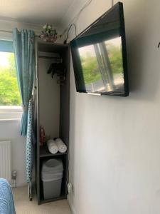 a mirror hanging on a wall next to a window at Enjoy your stay at Chorley Road in Droitwich