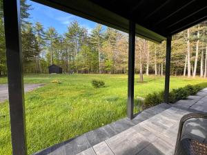 un porche cubierto con vistas a un campo de césped en Ginger House - Charming 3 bedroom cottage 4 min from Woodstock, en Woodstock
