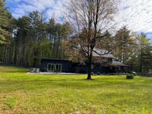 una casa en medio de un campo con un árbol en Ginger House - Charming 3 bedroom cottage 4 min from Woodstock, en Woodstock