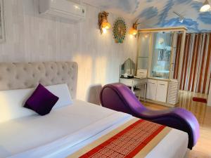 1 dormitorio con 1 cama con silla morada en NGỌC HƯNG HOTEL, en Vĩnh Long