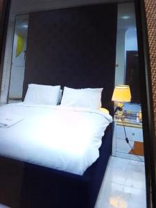 ラゴスにあるKoko HOMES LEKKI PHASE 1のベッドルーム(白い大型ベッド1台、黒いヘッドボード付)