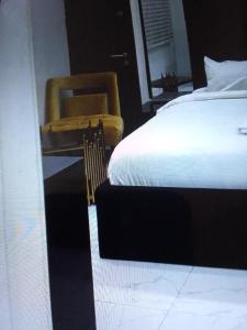 拉各斯的住宿－Koko HOMES LEKKI PHASE 1，一间卧室配有一张床、一把椅子和镜子