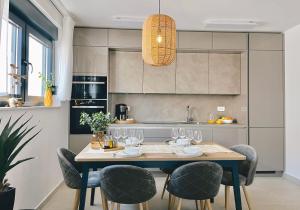 een keuken met een tafel met wijnglazen erop bij Apartment Agnes with 63 m2 Rooftop Terrace, Grill and Pool in Okrug Gornji