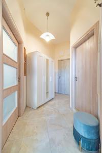 a large hallway with a door and a blue stool at Magnifica La Mer in Golden Sands