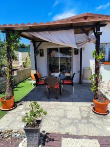 uma pérgola com uma mesa e cadeiras num quintal em Villa Daita 1 em Granadilla de Abona