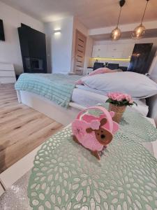 ein Schlafzimmer mit 2 Betten und einem Teddybär auf dem Bett in der Unterkunft Apartament z kominkiem nad Jeziorem Czorsztyńskim in Frydman