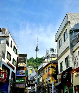 uma rua da cidade com uma torre de tv ao fundo em Look Home Guesthouse em Seul