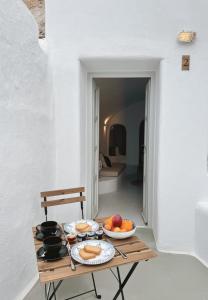 a table with bowls of fruit on it in a room at as holiday caves in Mesaria