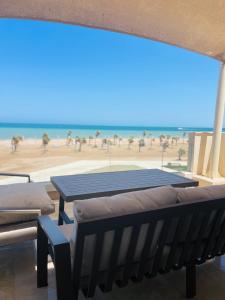 stół i ławki z widokiem na plażę w obiekcie Mangroovy Residence El Gouna - Grovin w mieście Hurghada