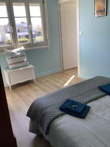 Un dormitorio con una cama con una toalla azul encima. en Ker LN, en Saint-Nazaire