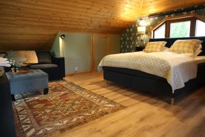 ein Schlafzimmer mit einem Bett und einem Sofa in der Unterkunft Villa Granliden in Ludvigsborg
