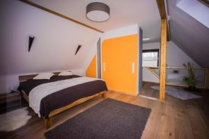 ein Schlafzimmer mit einem Bett und einer orangefarbenen Wand in der Unterkunft Haus Solveig in Wieda