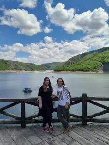 two women standing on a pier near a body of water at Vila Helena -Apartman 3 in Nova Varoš